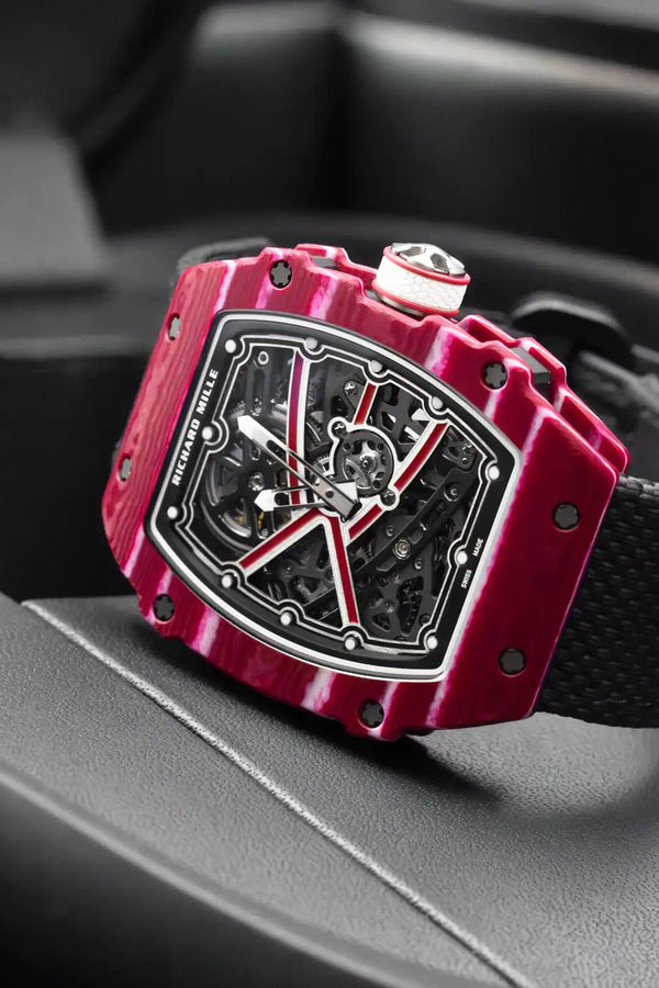 Red watch with a black strap on a car dashboard
