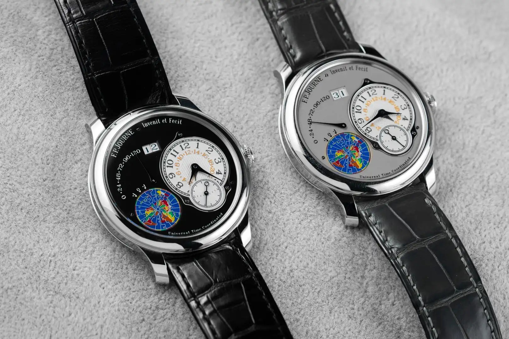 Two luxury watches with intricate designs on a gray surface